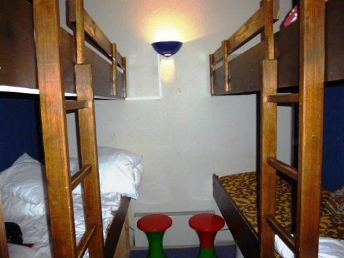 une chambre avec deux lits superposés et deux tabourets rouges dans l'établissement Studio pour 6 à Arette avec accès pistes, balcon, casier à skis et parkings gratuits - FR-1-602-20, à Arette