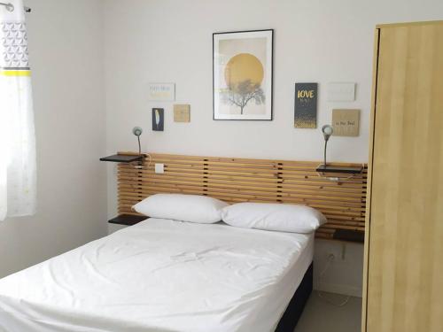 Schlafzimmer mit einem weißen Bett mit einem Kopfteil aus Holz in der Unterkunft Appartement Arette, 3 pièces, 6 personnes - FR-1-602-61 in Arette