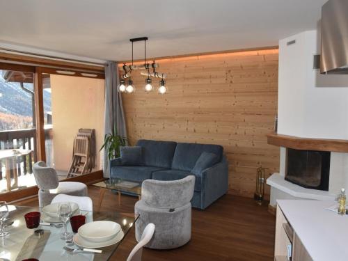 un salon avec un canapé bleu et des chaises dans l'établissement Duplex rénové 3 chambres avec wi-fi, garage, balcon sud, proche pistes à Montgenèvre - FR-1-266-162, à Montgenèvre