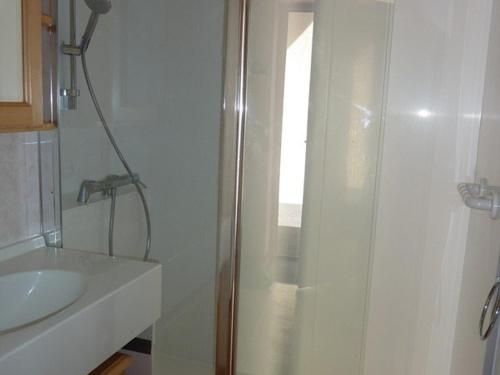 une salle de bain blanche avec une douche et un lavabo dans l'établissement Appartement cosy 6 pers. proche pistes avec balcon, casier à skis et parking couvert - FR-1-573-32, à Saint-Jean-dʼAulps