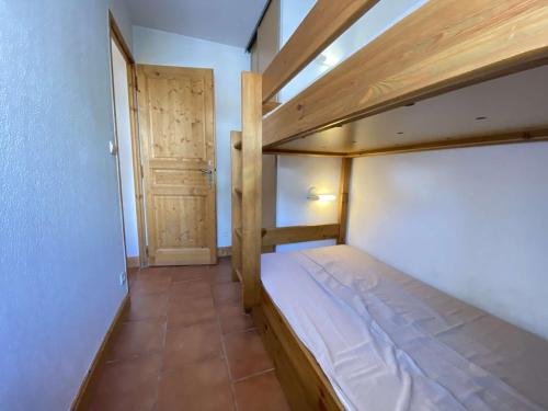 - une petite chambre avec des lits superposés et une porte dans l'établissement Studio Cabine à Praz-Sur-Arly, proche village et pistes, balcon, parking, piscine, 4 pers - FR-1-603-18, à Praz-sur-Arly