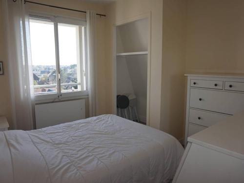 a bedroom with a white bed and a window at Appartement Cabourg, 2 pièces, 4 personnes - FR-1-465-61 in Cabourg