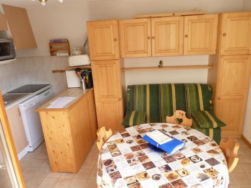 une petite cuisine avec une table et une chaise dans l'établissement Charmant 2 pièces avec balcon, départ des randonnées, parking et ascenseur - FR-1-573-33, à Bonnevaux