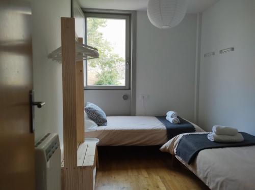 Habitación pequeña con 2 camas y ventana en A casa da Pena Vixia, en Ourense