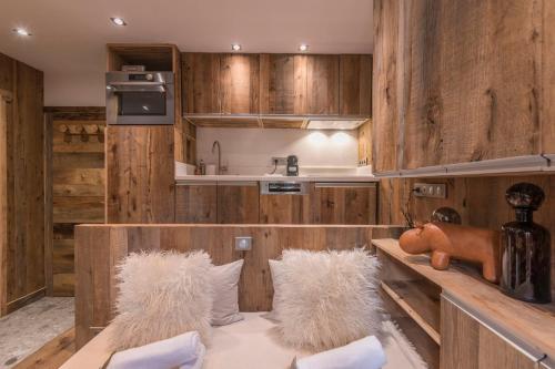 cocina con paredes de madera y sillas acolchadas blancas en Studio Cristallin - Welkeys en Megève