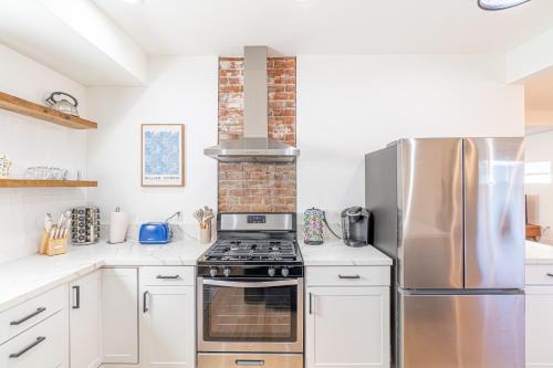a kitchen with white cabinets and a stove and refrigerator at Luxury 4-bed home in Riverside Heights! in Reno