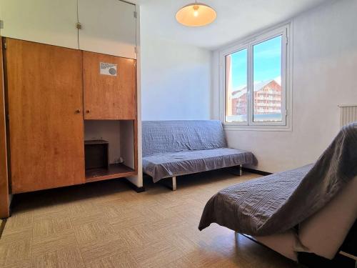 - une chambre avec un lit, une armoire et une fenêtre dans l'établissement Studio confortable, accès pistes à 50m, parking gratuit, navette proche - FR-1-525-208, à Saint-Étienne-en-Dévoluy