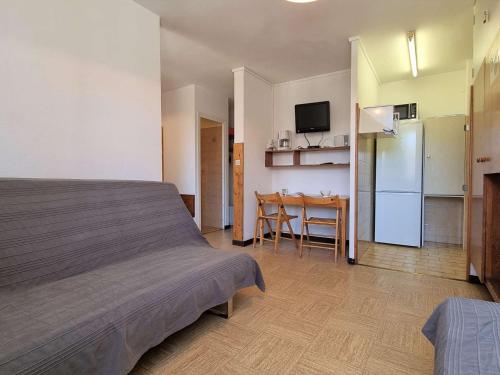 une chambre avec un lit et une cuisine avec une table dans l'établissement Studio confortable, accès pistes à 50m, parking gratuit, navette proche - FR-1-525-208, à Saint-Étienne-en-Dévoluy
