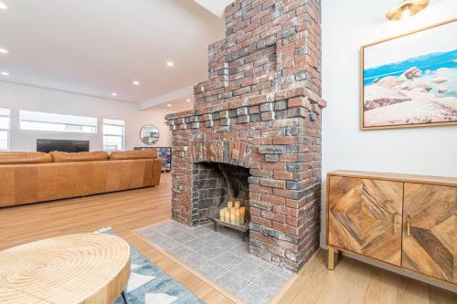 a brick fireplace in a living room with a couch at Luxury 4-bed home in Riverside Heights! in Reno