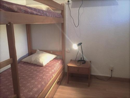 a bedroom with two bunk beds and a lamp on a night stand at Appartement Risoul, 2 pièces, 5 personnes - FR-1-330-533 in Risoul