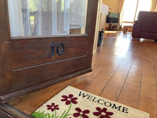 a welcome mat in front of a door with a welcome sign at No 10 Coastguard Station in Renvyle