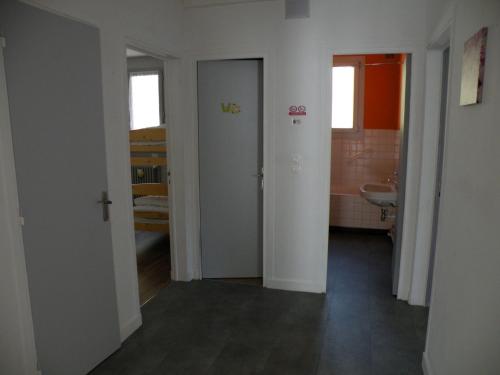 een hal met twee deuren en een wastafel in een kamer bij Coquelicot, Entre Volcans d Auvergne et Sancy, Orcival. in Orcival