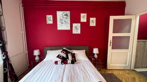 Un dormitorio con una pared roja y una cama en Parrag Panzió Mátraszentlászló, en Mátraszentimre
