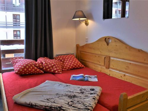 une chambre avec un lit avec des oreillers dessus dans l'établissement Studio cabine 6 pers à Risoul 1850, skis aux pieds, balcon sud, proche navette gratuite - FR-1-330-544, à Risoul