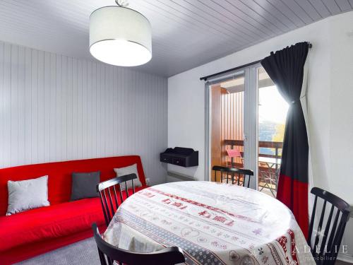 - une chambre avec un lit rouge et un canapé rouge dans l'établissement Studio spacieux 4/6 pers, au pied des pistes, balcon sud-ouest, proche commerces - FR-1-398-639, à Montvalezan