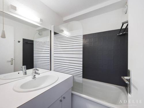 La salle de bains blanche est pourvue d'un lavabo et d'une baignoire. dans l'établissement Studio spacieux 4/6 pers, au pied des pistes, balcon sud-ouest, proche commerces - FR-1-398-639, à Montvalezan