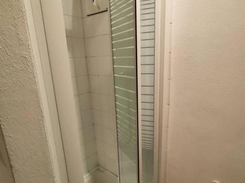 een douche met een glazen deur in de badkamer bij Appartement Cauterets, 2 pièces, 4 personnes - FR-1-234-271 in Cauterets