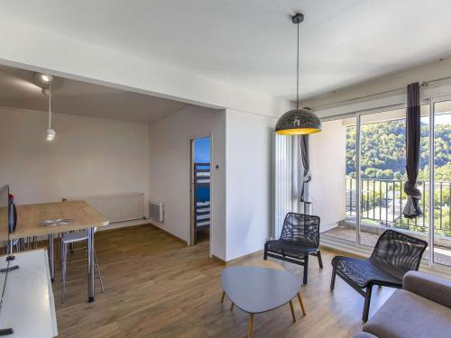 un salon avec une table, des chaises et un canapé dans l'établissement Appartement rénové 8 pers, terrasse, ski, wifi - FR-1-400-106, à Eaux-Bonnes