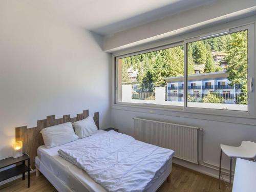 une chambre avec un lit et une grande fenêtre dans l'établissement Appartement rénové 8 pers, terrasse, ski, wifi - FR-1-400-106, à Eaux-Bonnes
