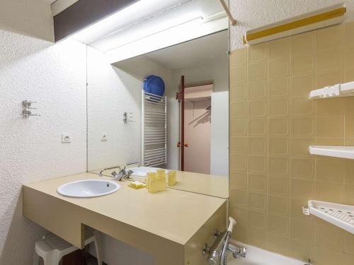 een badkamer met een wastafel en een spiegel bij Appartement La Mongie, 2 pièces, 6 personnes - FR-1-404-335 in Bagnères-de-Bigorre