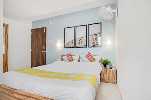 um quarto com uma grande cama branca com almofadas listradas em Goroomgo Dream LIne Kalikapur Kolkata em Calcutá
