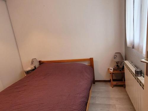 een slaapkamer met een bed met een rode sprei bij Appartement Le Biot, 2 pièces, 6 personnes - FR-1-573-56 in Le Biot