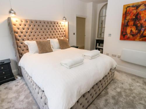 1 dormitorio con 1 cama grande y cabecero grande en The Penthouse, en York