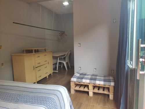 1 dormitorio con cama, escritorio y silla en Casa do Sossego, en Brasilia