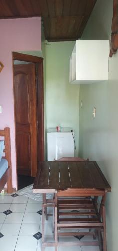 a kitchen with a wooden table in a room at Chateu Soneca in Algodoal