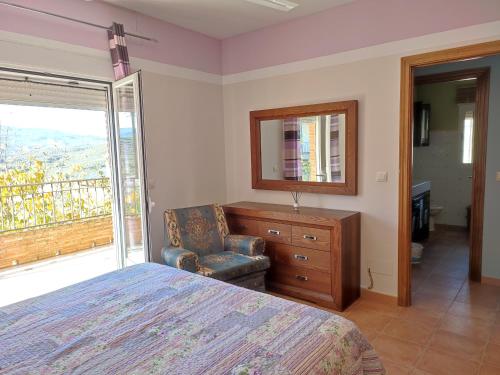 a bedroom with a bed and a dresser and a mirror at Villa Spa Los Villares in Jaén