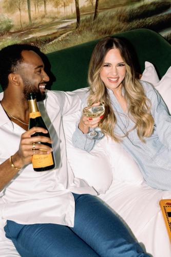 a man and a woman sitting on a couch with a bottle of wine at Virgin Hotels New Orleans in New Orleans