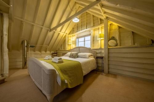 ein Schlafzimmer mit einem großen Bett im Dachgeschoss in der Unterkunft The Dairy at Green Valley Farm in Laxfield