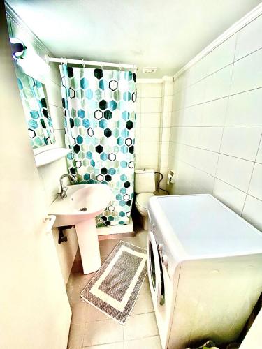 a bathroom with a washing machine and a sink at Feel Home Studio in Mytilene