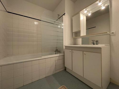 een badkamer met een bad, een wastafel en een douche bij Appartement Saint-Martin-de-Ré, 3 pièces, 4 personnes - FR-1-246C-21 in Saint-Martin-de-Ré