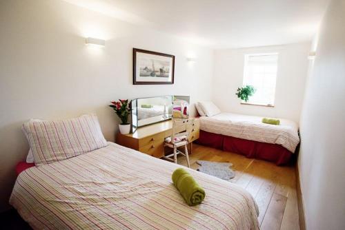 a small bedroom with two beds and a desk at Big Moo in Llanrhyddlad