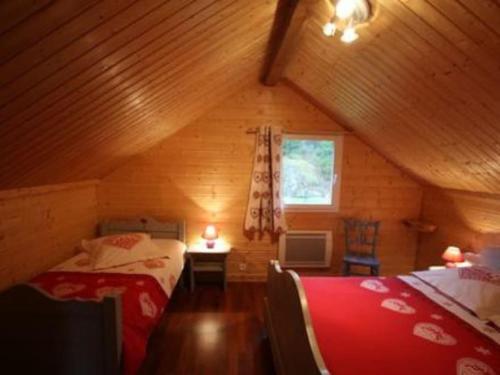 a attic bedroom with two beds and a window at chalet de montagne in Vagney