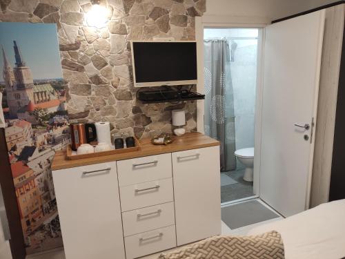 łazienka z telewizorem na górze szafki w obiekcie Room Marija w Zagrzebiu