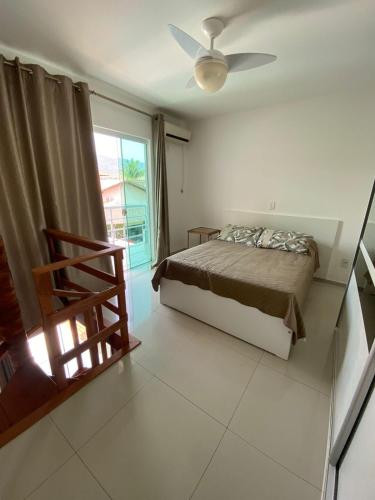 1 dormitorio con cama y ventana en Casa de Hóspedes com Piscina em Porto Belo, en Porto Belo