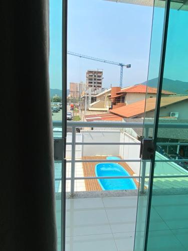 una ventana con vistas a la piscina en Casa de Hóspedes com Piscina em Porto Belo, en Porto Belo