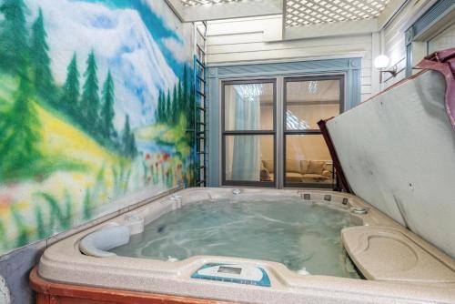 una vasca idromassaggio in una stanza con un murale di West End Splendor by Snowmass Vacations ad Aspen