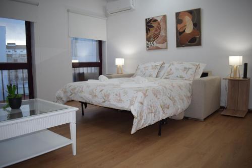 a white bedroom with a bed and a couch at Terreiro da Erva House 2 in Coimbra