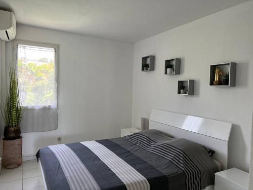 Habitación blanca con cama y ventana en Zabana Lodge, dans un jardin tropical avec piscine en Saint-Claude