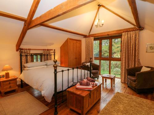 a bedroom with a bed and a couch and a chair at Stone Barn in Holsworthy