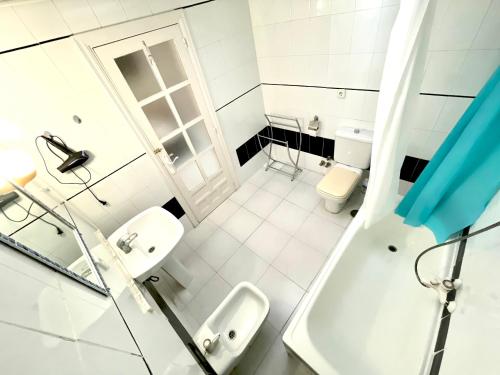 a white bathroom with two sinks and a shower at Las habitaciones de Svetlana in Alicante