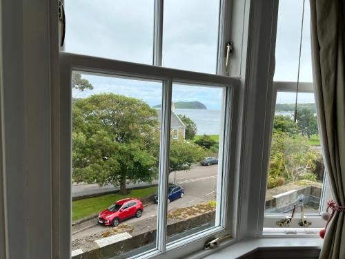 a window with a view of a red car on a street at Ardshiel Hotel in Campbeltown