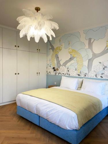 une chambre avec un grand lit et un lustre dans l'établissement Appartement luxueux hyper centre de Strasbourg, à Strasbourg