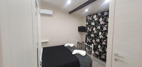 een kleine kamer met een bed met handdoeken erop bij Cortile Gallinaccio in Catania