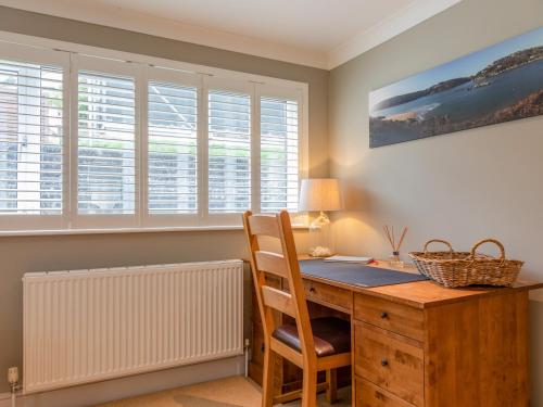 a home office with a wooden desk and a chair at Welsummer in Salcombe