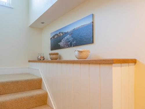 a room with stairs with a tv on the wall at Welsummer in Salcombe