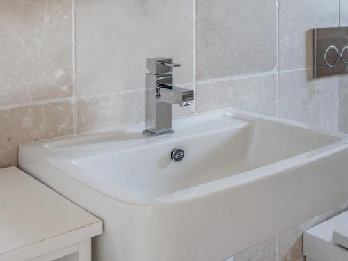 a white sink with a faucet in a bathroom at Welsummer in Salcombe